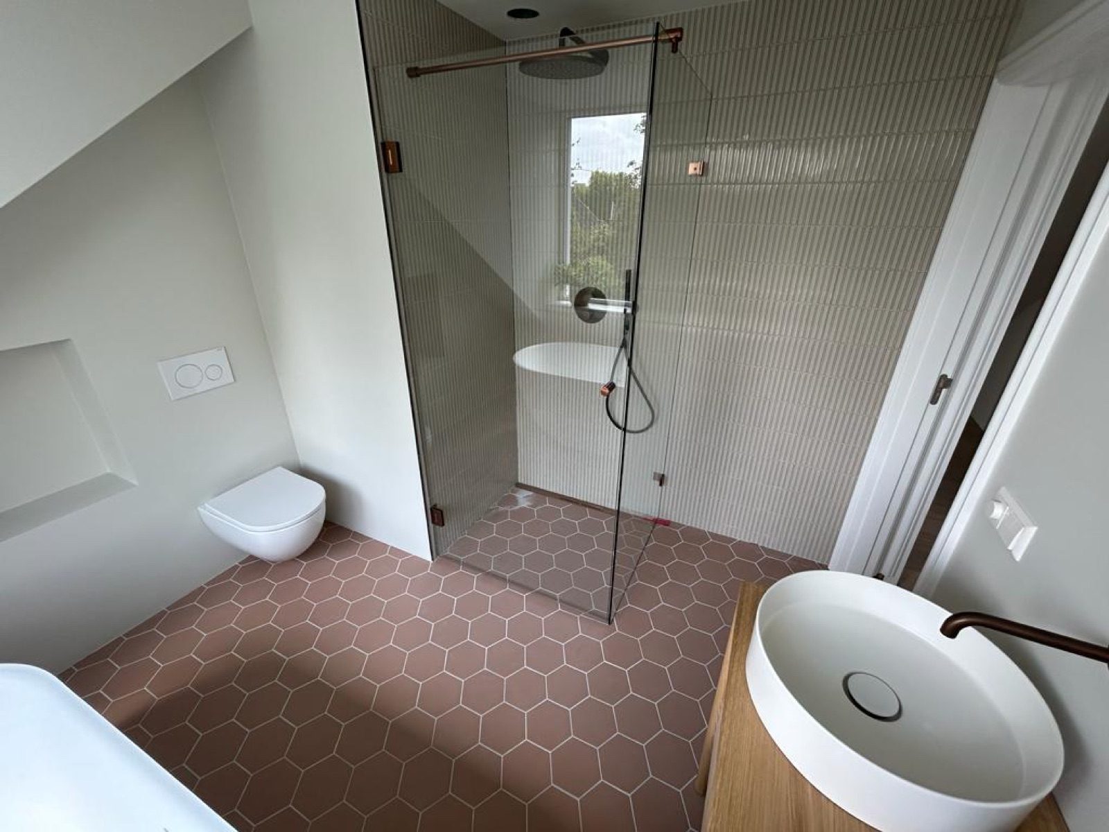 Completed bathroom with walk-in shower and hexagonal floor tiles