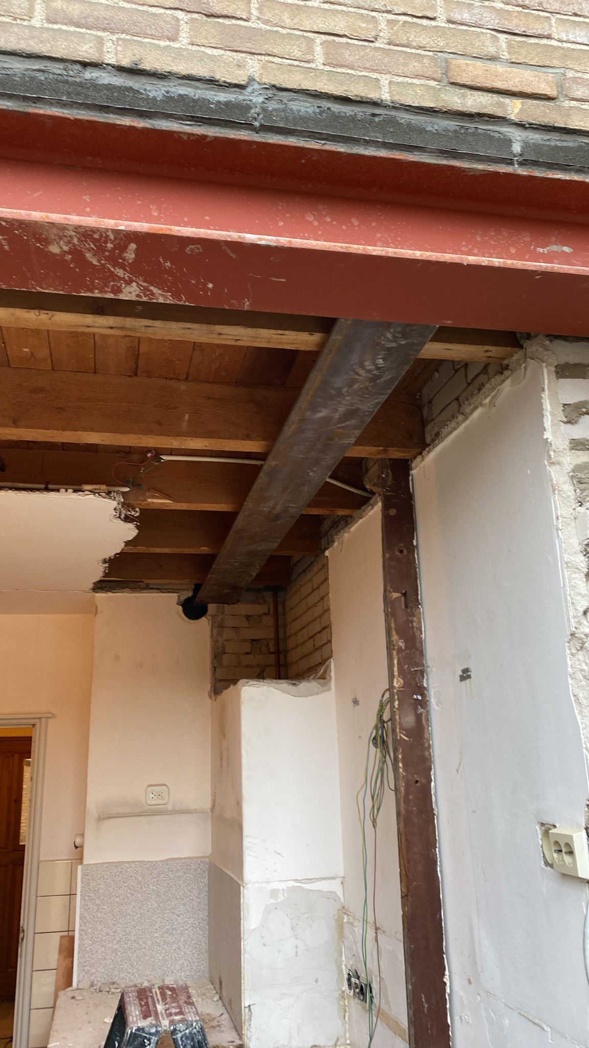 Stalen balk en open plafond bij een constructieve doorbraak